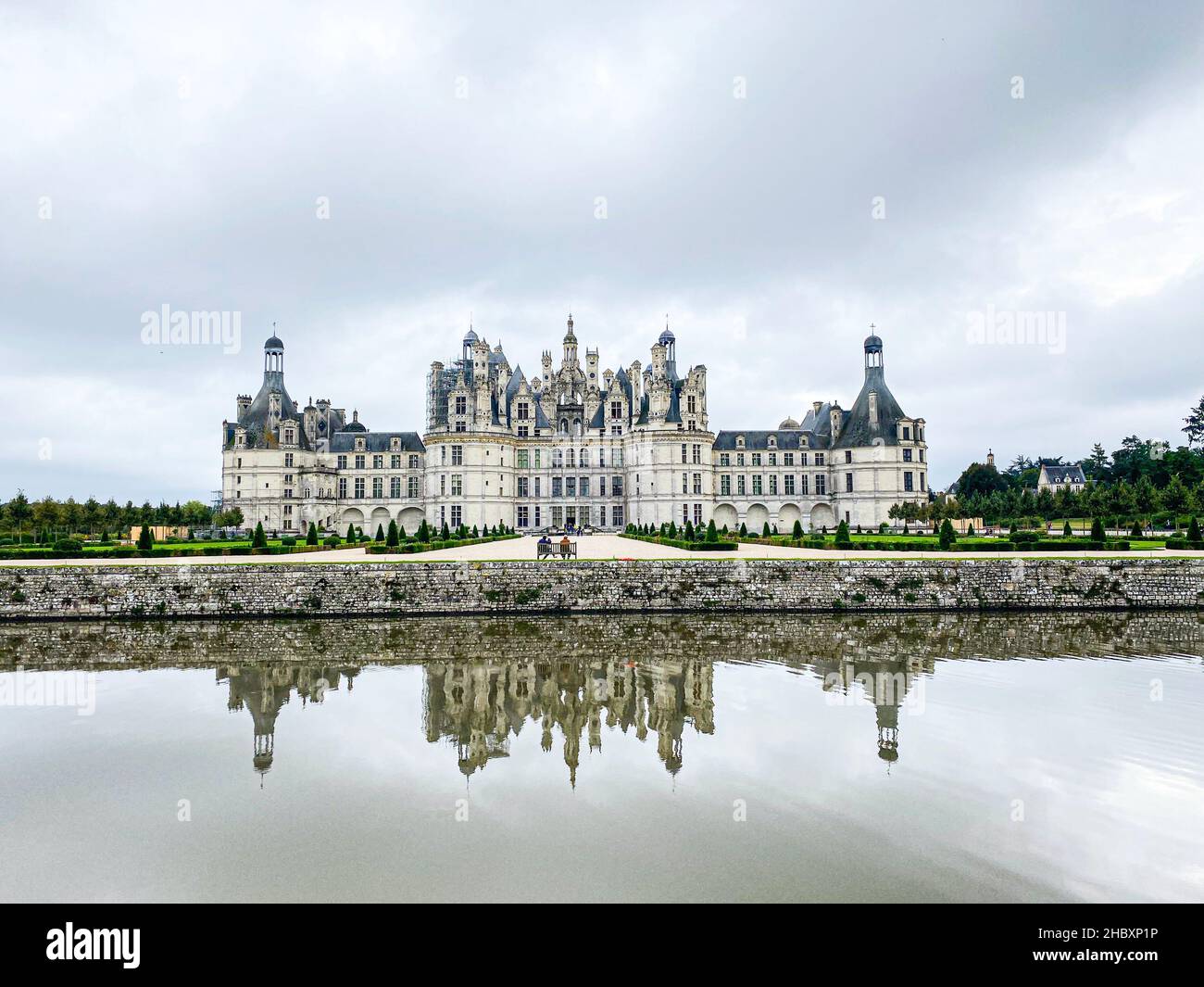 Vista grandangolare del Castello di Chambord nella valle della Loira, con i suoi giardini, giorno nuvoloso, riflessione d'acqua, Francia Foto Stock