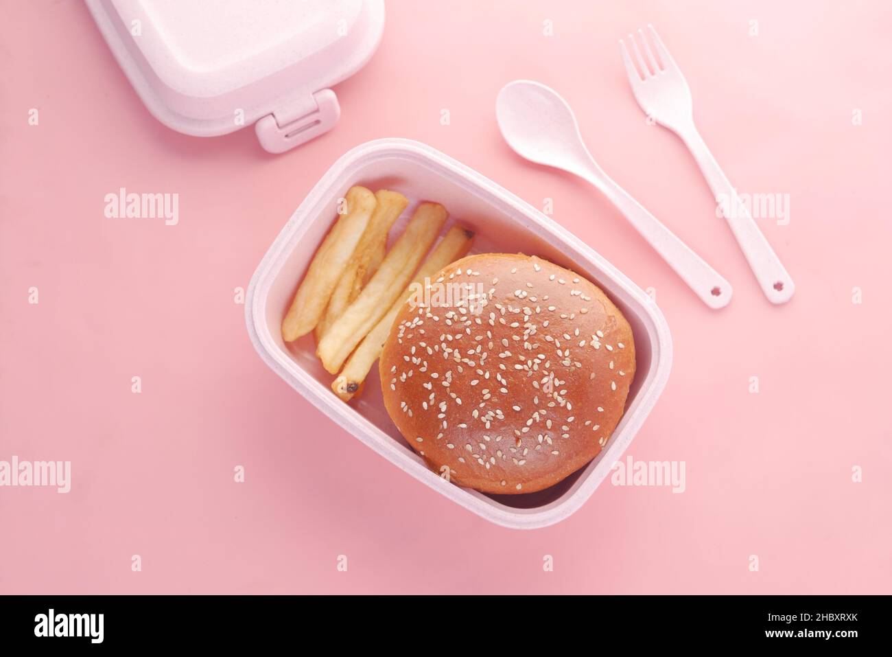 hamburger di manzo e amico francese in un pranzo al sacco su sfondo rosa Foto Stock