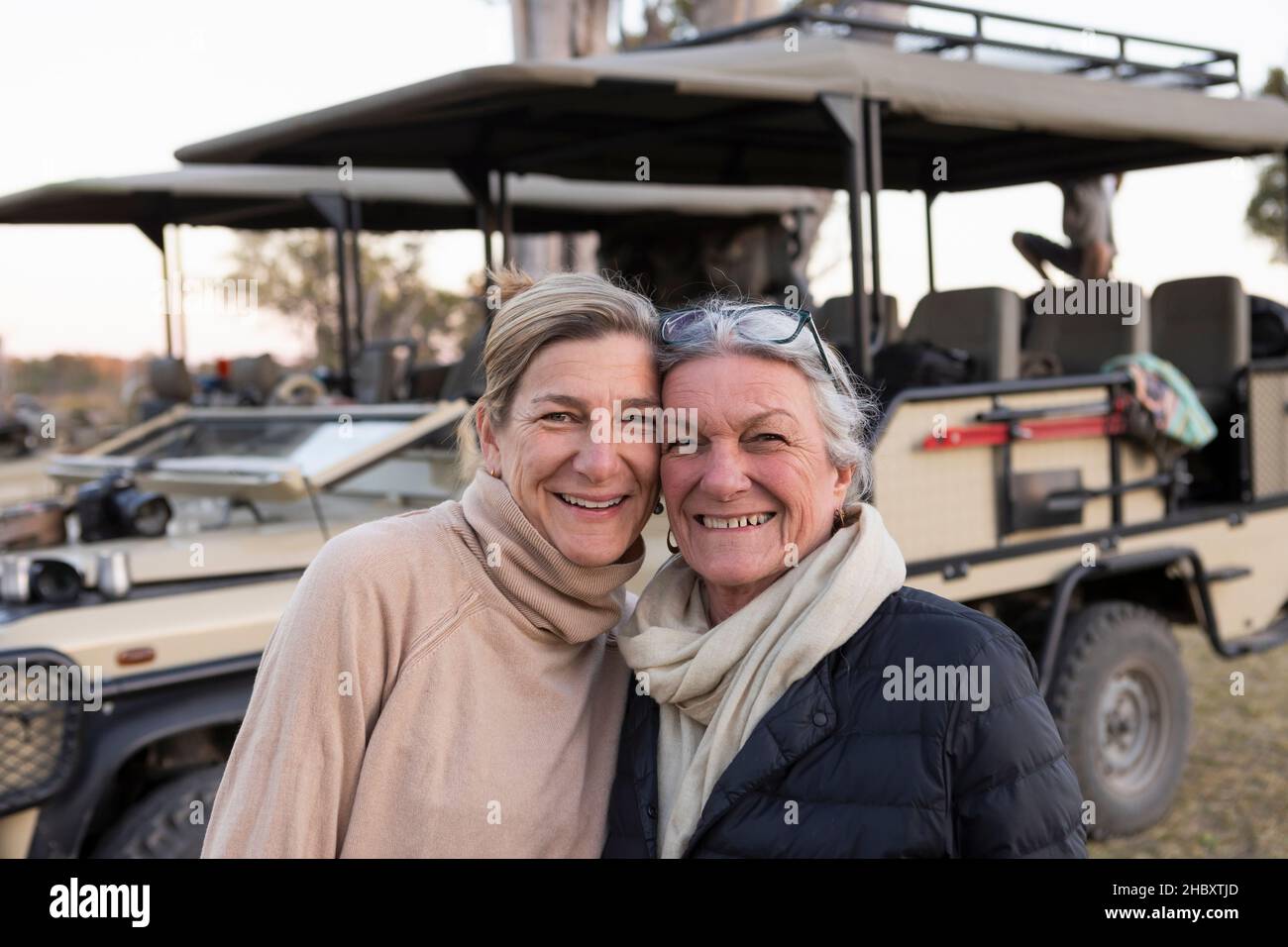 Due donne affiancate da un veicolo safari, donna adulta e sua madre, somiglianza familiare Foto Stock