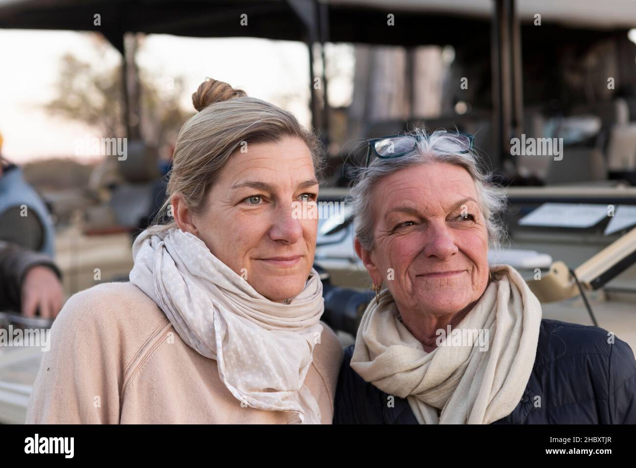 Due donne affiancate da un veicolo safari, donna adulta e sua madre, somiglianza familiare Foto Stock