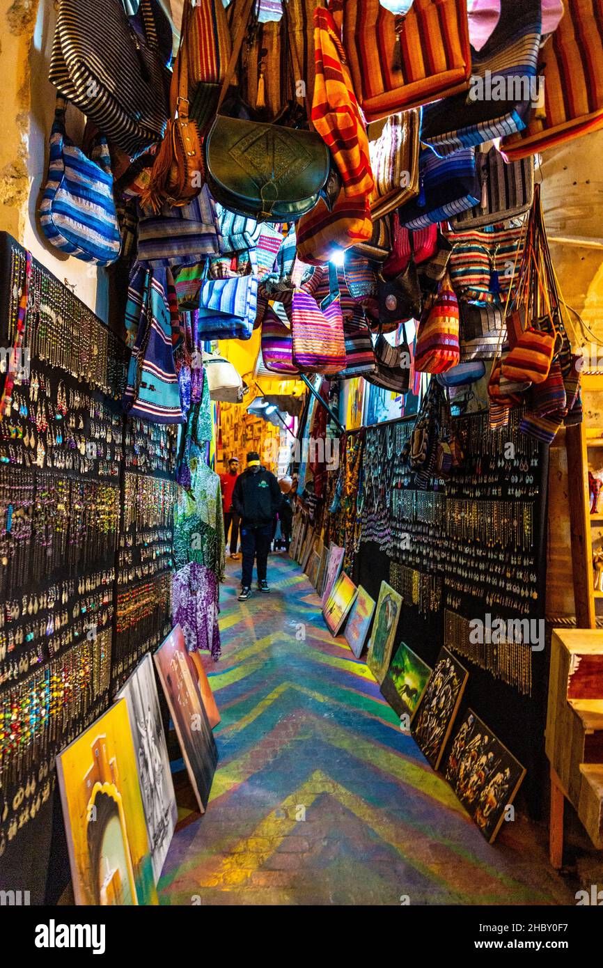 Stalla con gioielli e borse appesi su una strada stretta nei souk della medina, Fes, Marocco Foto Stock