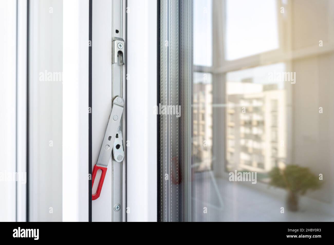 Cornice porta balcone in plastica bianca con accessori. Primo piano della leva di guida nascosta. Accessori e bulloneria per porte e finestre in PVC. Foto Stock