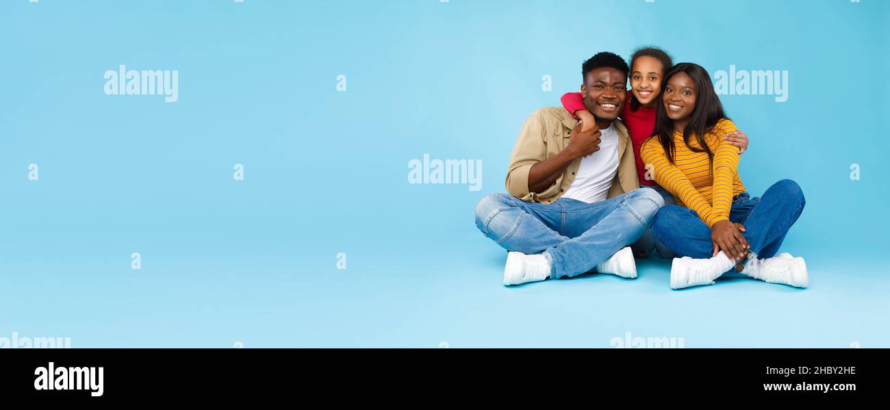Uomo, donna e ragazza afro-americani seduti a terra Foto Stock