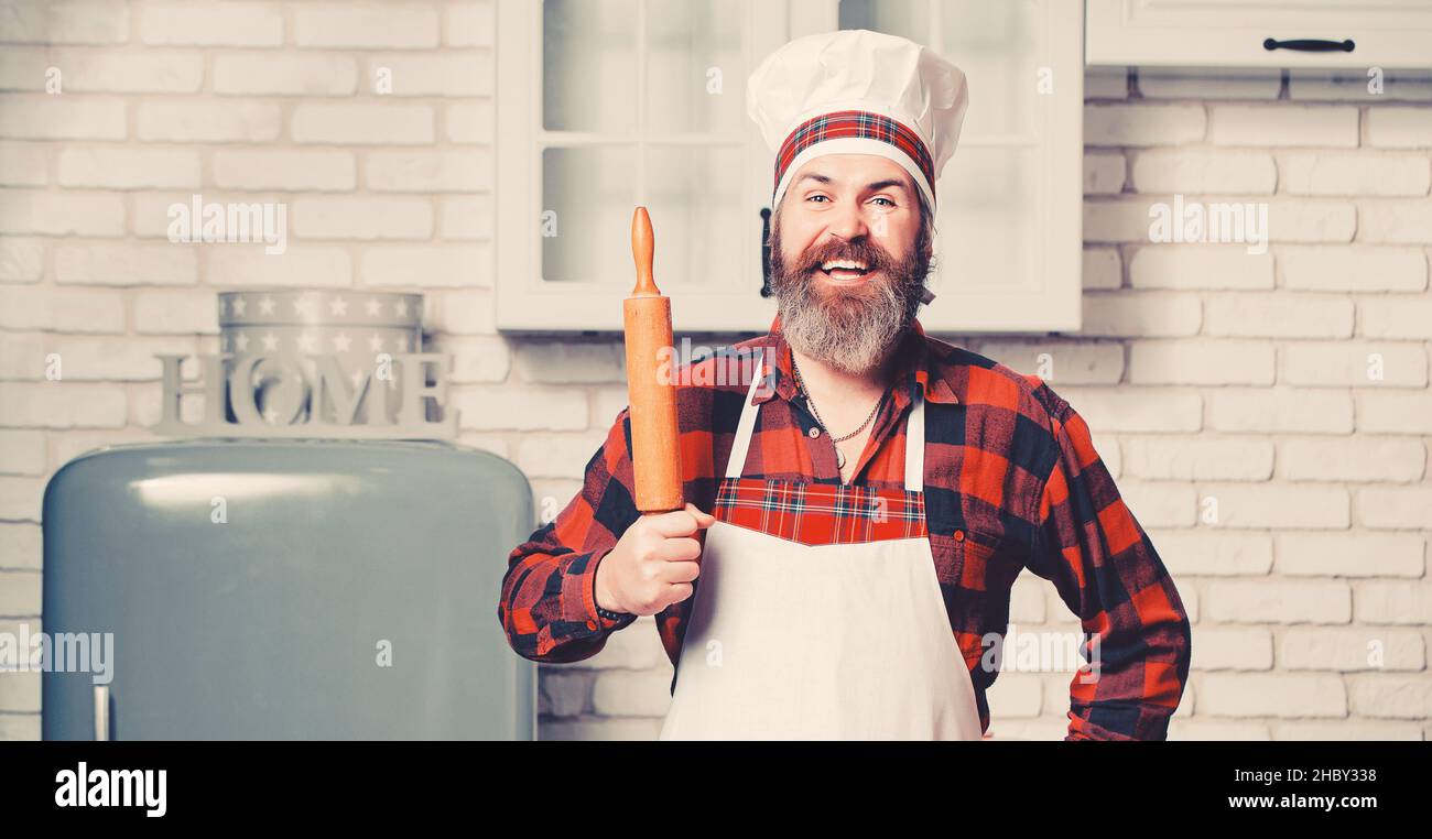 Lo chef cuoco con barba tiene una spilla su una cucina bianca. Foto Stock