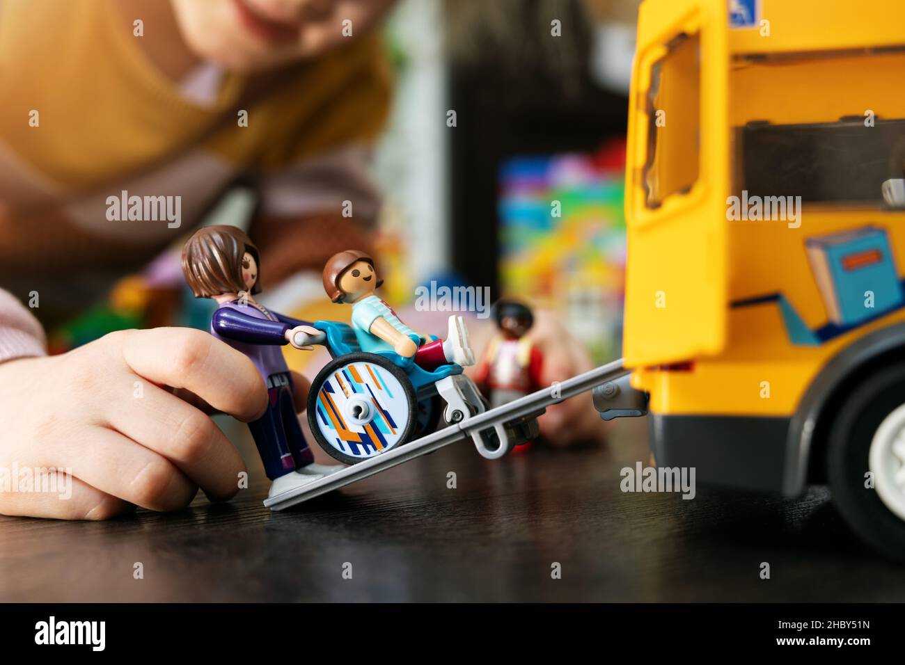 bambini che giocano con giocattoli sul pavimento. trasporto in autobus scolastico per bambini disabili su sedia a rotelle. concetto di accettazione disabilità Foto Stock