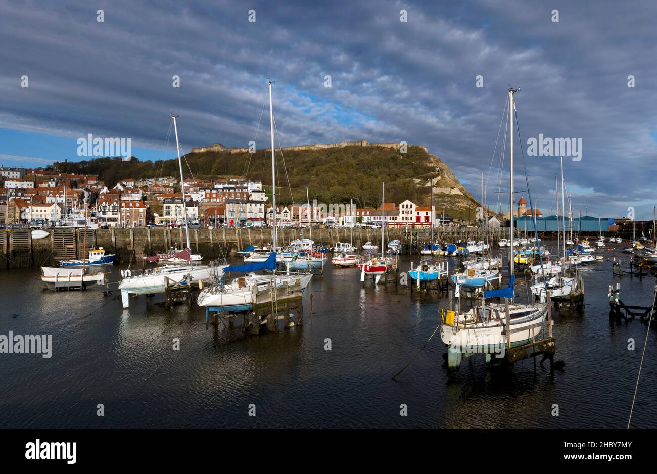 Barche nel porto con il castello sulla scogliera sopra, Scarborough, North Yorkshire, Regno Unito Foto Stock