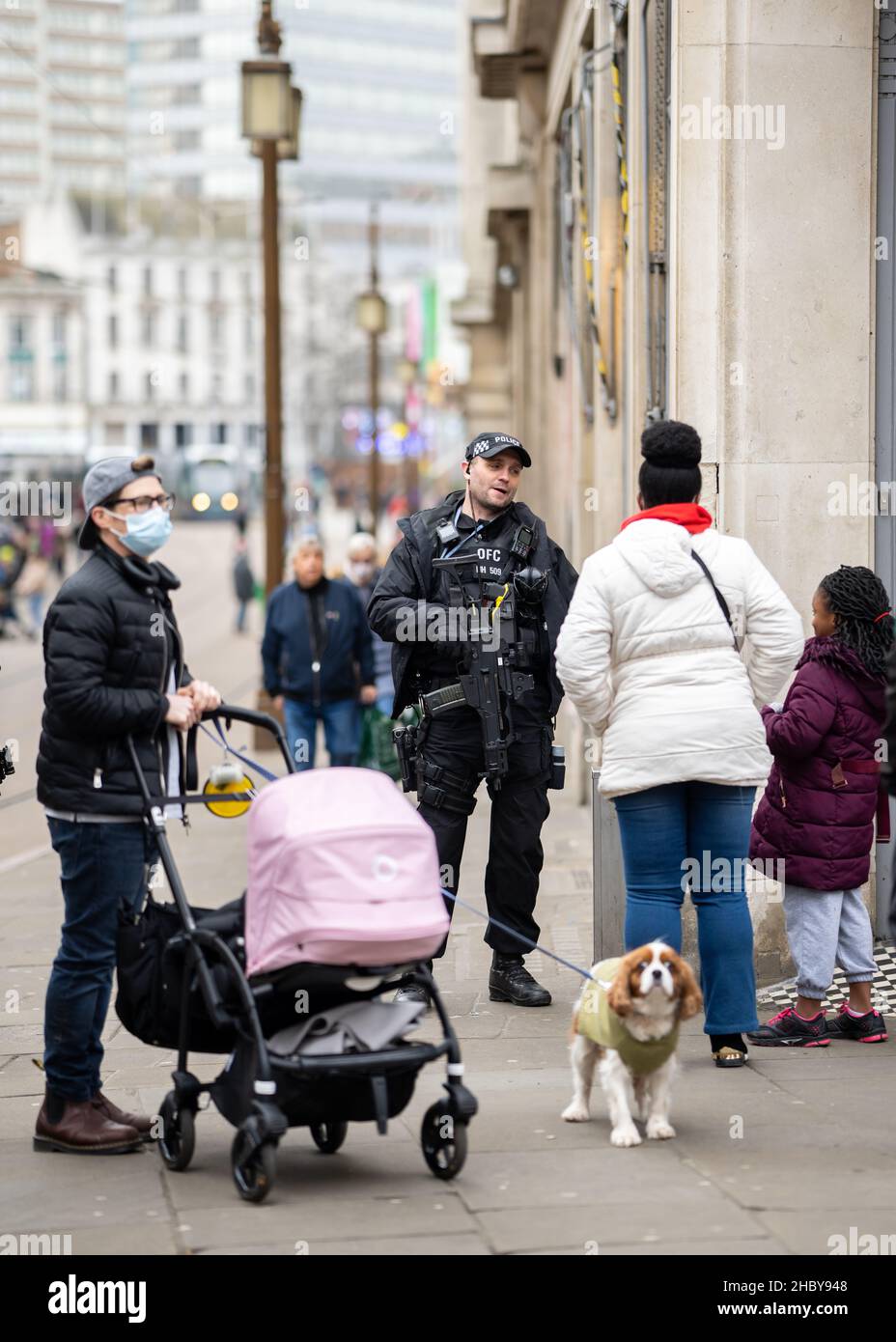 Poliziotto di risposta armato con armi da fuoco pattugliando la strada trafficata della città con il pubblico. Mitragliatrice e poliziotto di pistole in un'arma di presa uniforme Foto Stock