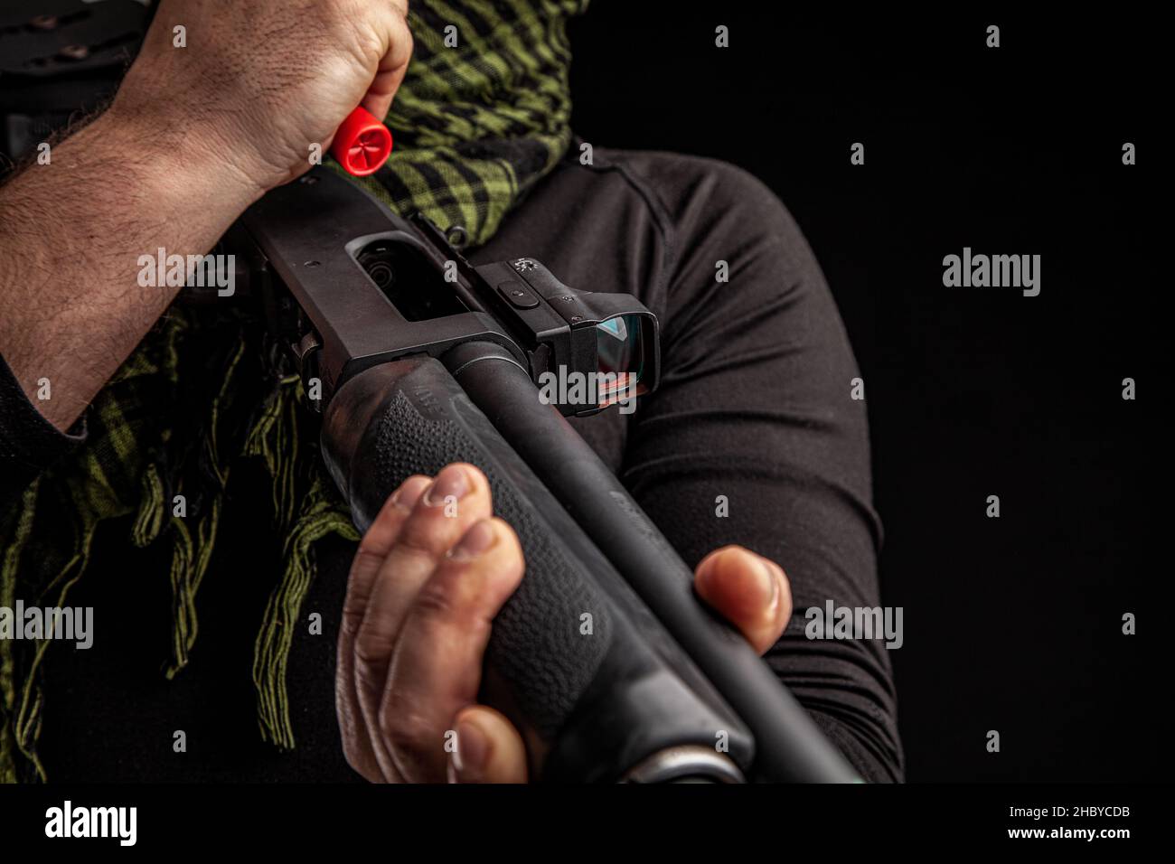 L'uomo carica il fucile con munizioni. Caricamento di un'arma con pompa a bore uniforme. Foto da primo piano. Foto Stock