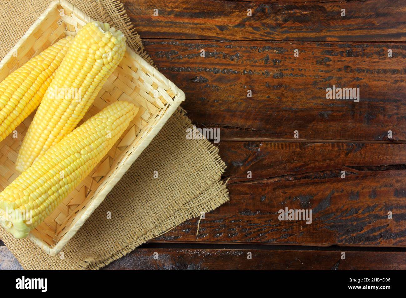 Materie di tutoli di mais, all'interno del cestello, raccolte dalla piantagione, su tavola in legno rustico. spazio per il testo. Vista superiore Foto Stock