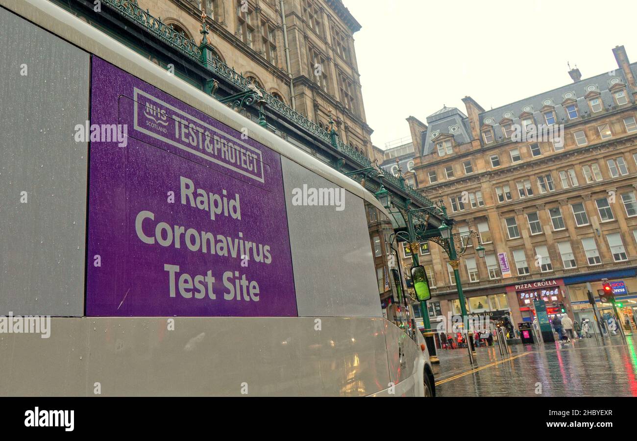 Glasgow, Scozia, Regno Unito 22nd dicembre 2021. UK Weather: Wet covid Christmas Streets ha visto la gente del posto lottare sotto la pioggia con i segni di Natale tutto intorno a loro la stazione ferroviaria centrale ha visto i tester covid in forve come una sede tarheted infornation..Credit Gerard Ferry/Alamy Live News Foto Stock