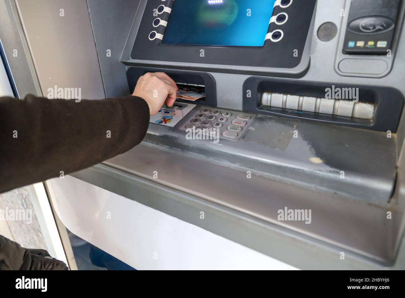 Mano della donna che ritira denaro da ATM. Foto Stock