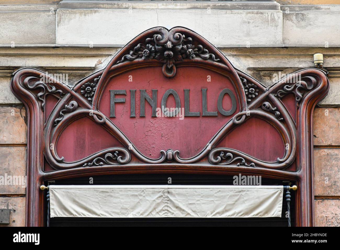 Primo piano dell'insegna in legno in stile Art Nouveau del negozio storico  Finollo, realizzato con magliette su misura e cravatte di seta, nel centro  di Genova, in Liguria, Italia Foto stock -