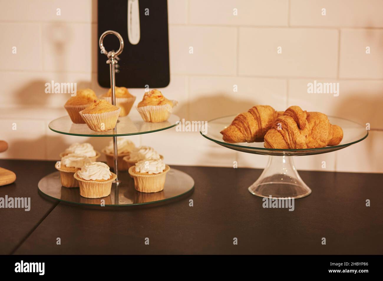 Tavolo da cucina con panetteria fresca: Muffin e croissant Foto Stock