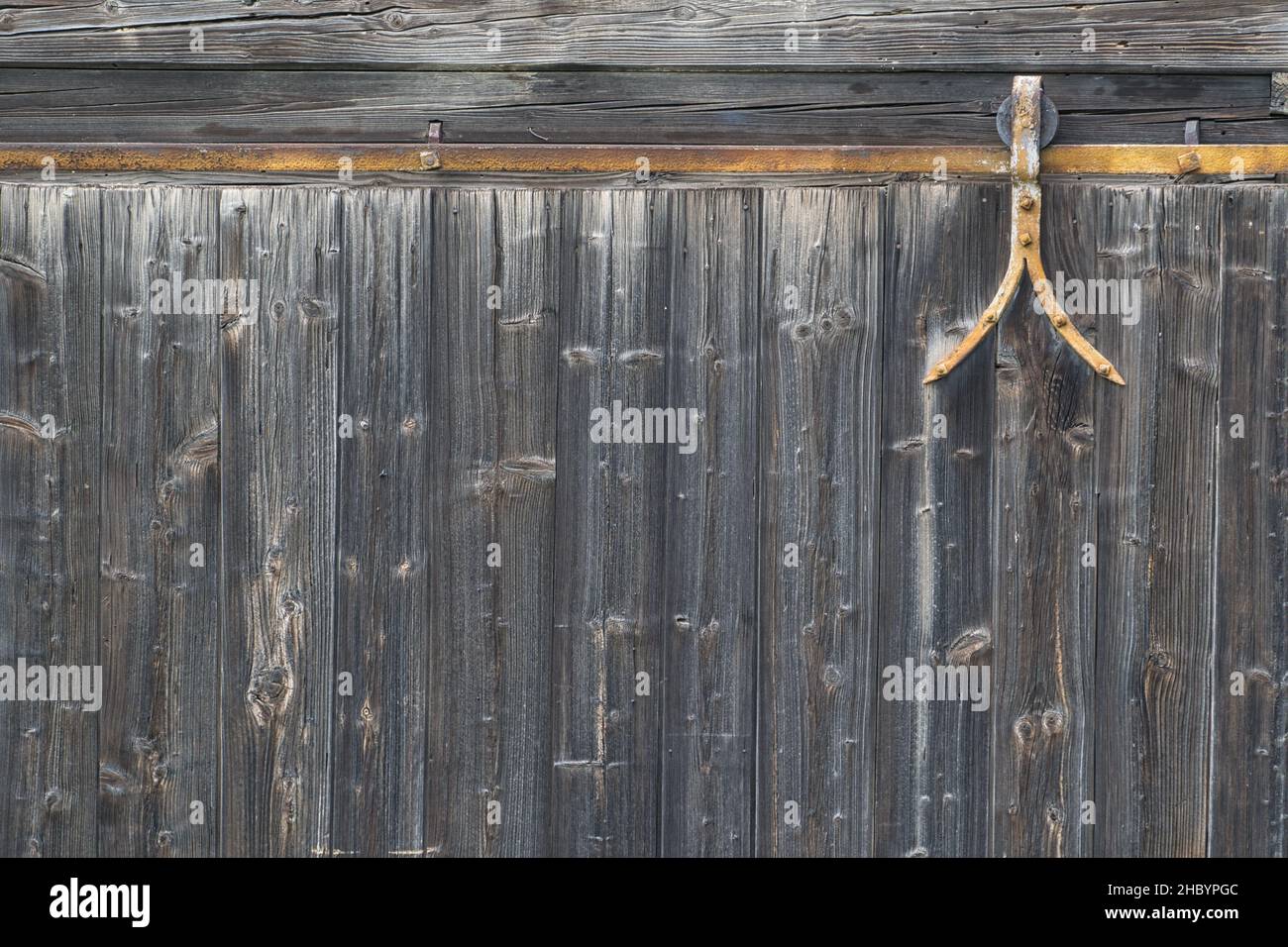 alte rustikale verwitterte Bretter, Bretterwand, Holztor mit Eisenbeschlägen und Aufhängung Foto Stock