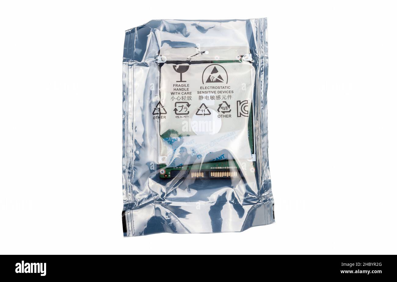Nuovo disco rigido, disco rigido, disco all'interno di un contenitore in lamina di protezione antistatica argentato isolato su bianco, tagliato. Spedizione e trasposizione di dispositivi elettronici Foto Stock