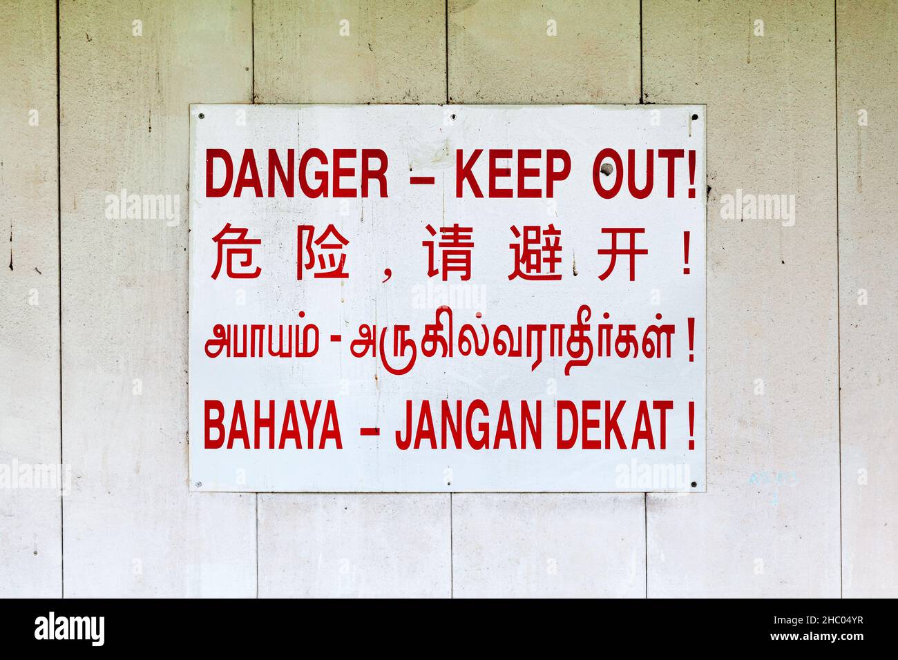 Singaporian Nessun segno di entrata che dice (pericolo - tenere fuori) in 4 lingue: Inglese, cinese, tamil e indonesiano. Foto Stock