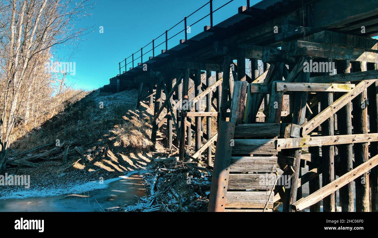 Supporti in legno per un ponte ferroviario su un fiume ghiacciato. Foto Stock
