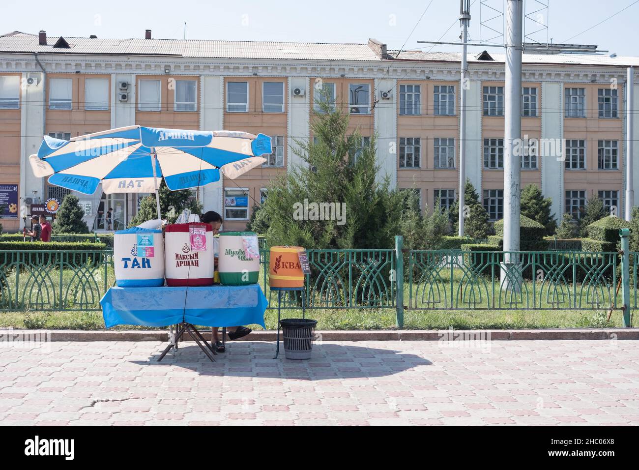 Donna vende pane tradizionale, grano e joghurt bevande a Bishkek, Kirghiztan Foto Stock