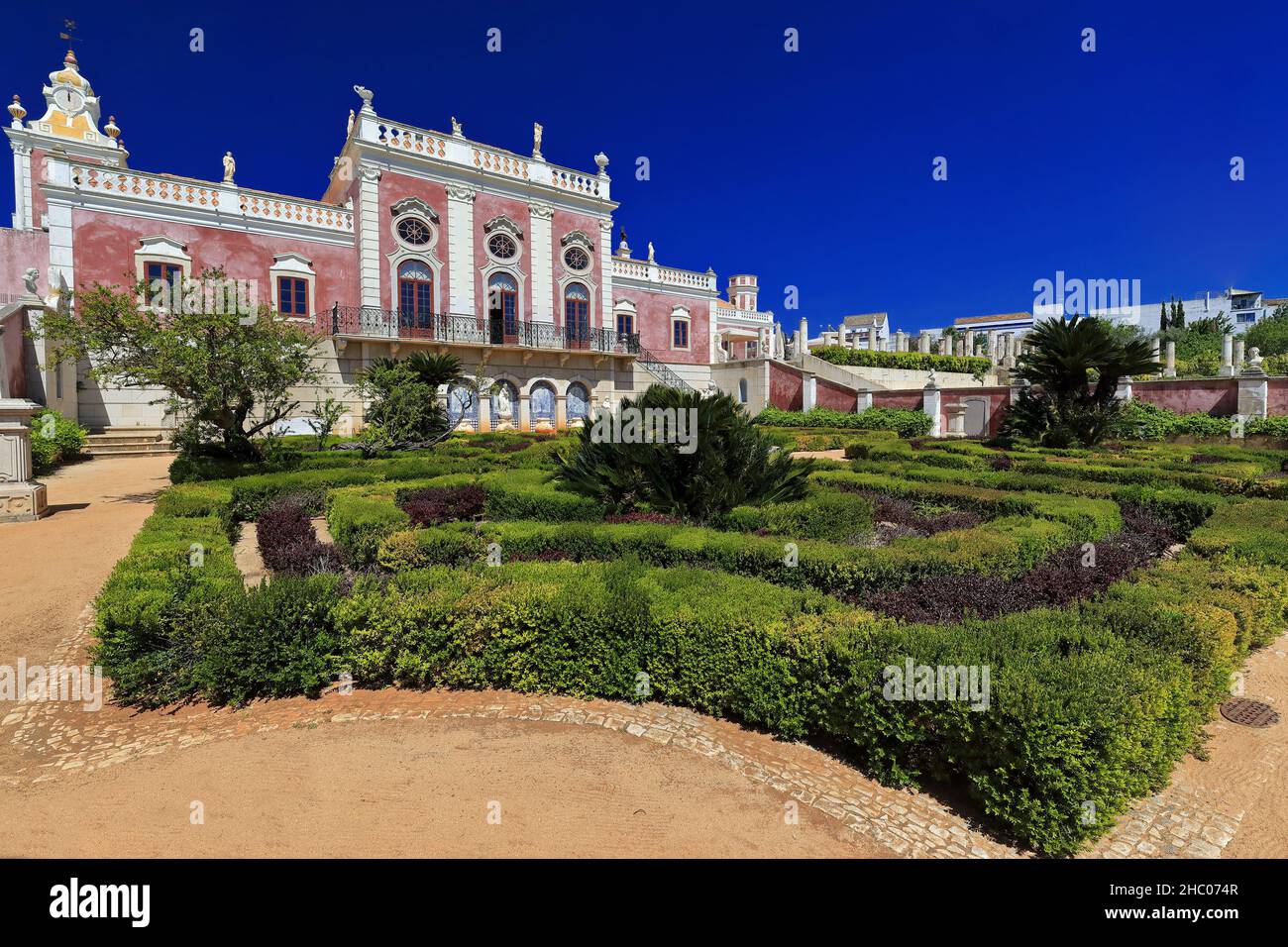 Facciata sud-palazzo neococococococo-sentiero ghiaia-siepi rifiniti-torre dell'orologio-lungo balcone-finestre oblò-statue sul tetto. Estoi-Algarve-Portogallo-029 Foto Stock