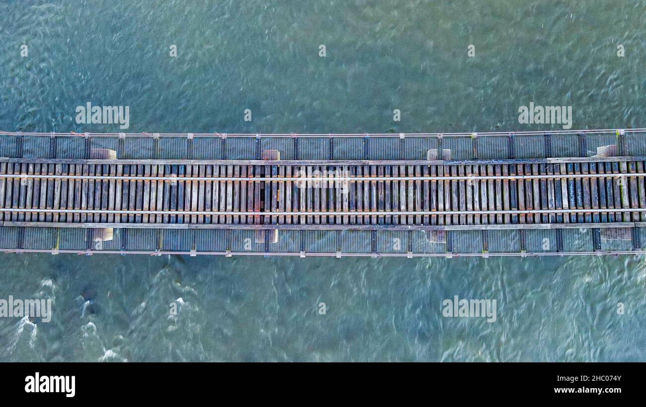 Il ponte ferroviario si muove attraverso l'acqua con acqua fluente sotto. Foto Stock