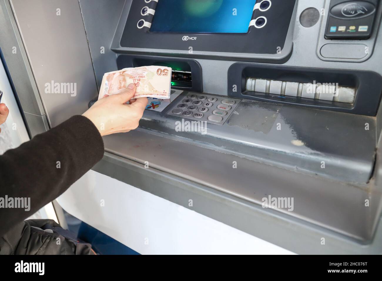 Mano della donna che ritira denaro da ATM. Foto Stock