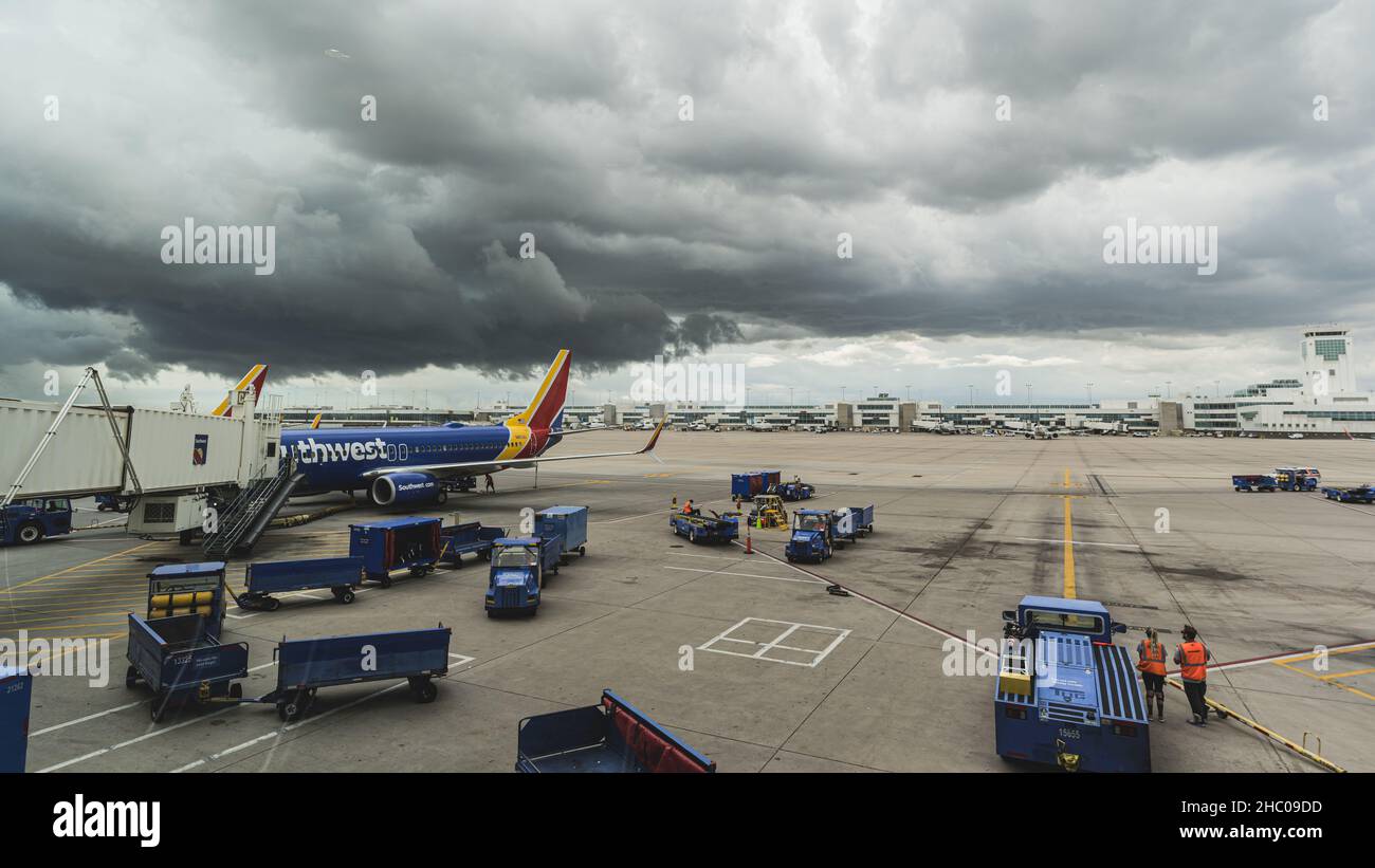 Le spettacolari nuvole di tempesta si aggrappano al cancello dell'aeroporto mentre l'aereo si siede sull'asfalto Foto Stock