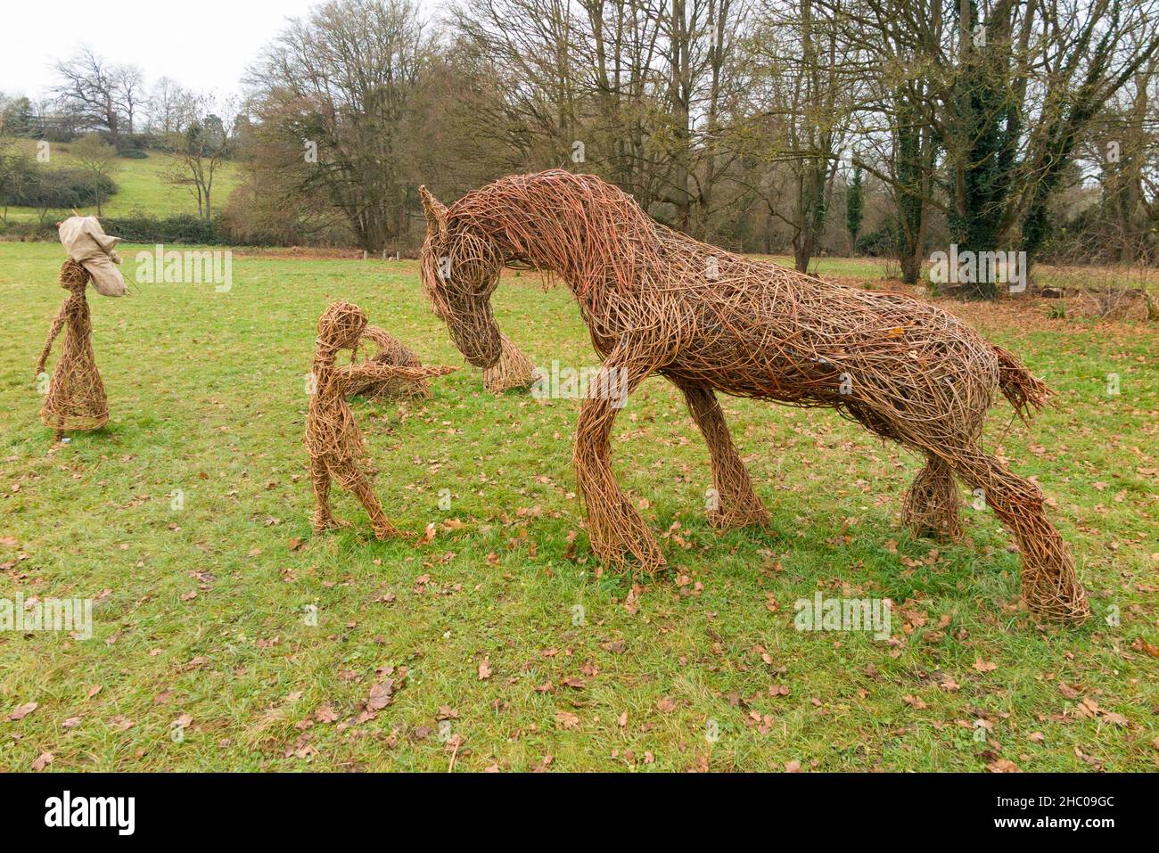 Scultura di persone antiche modellato da rami di Willow durante il periodo del raccolto e con il cavallo Shire e attrezzi scythe, in mostra a Runnymede, Surrey. REGNO UNITO. Runnymede fu il luogo della firma della Magna carta nel 1215. (127) Foto Stock