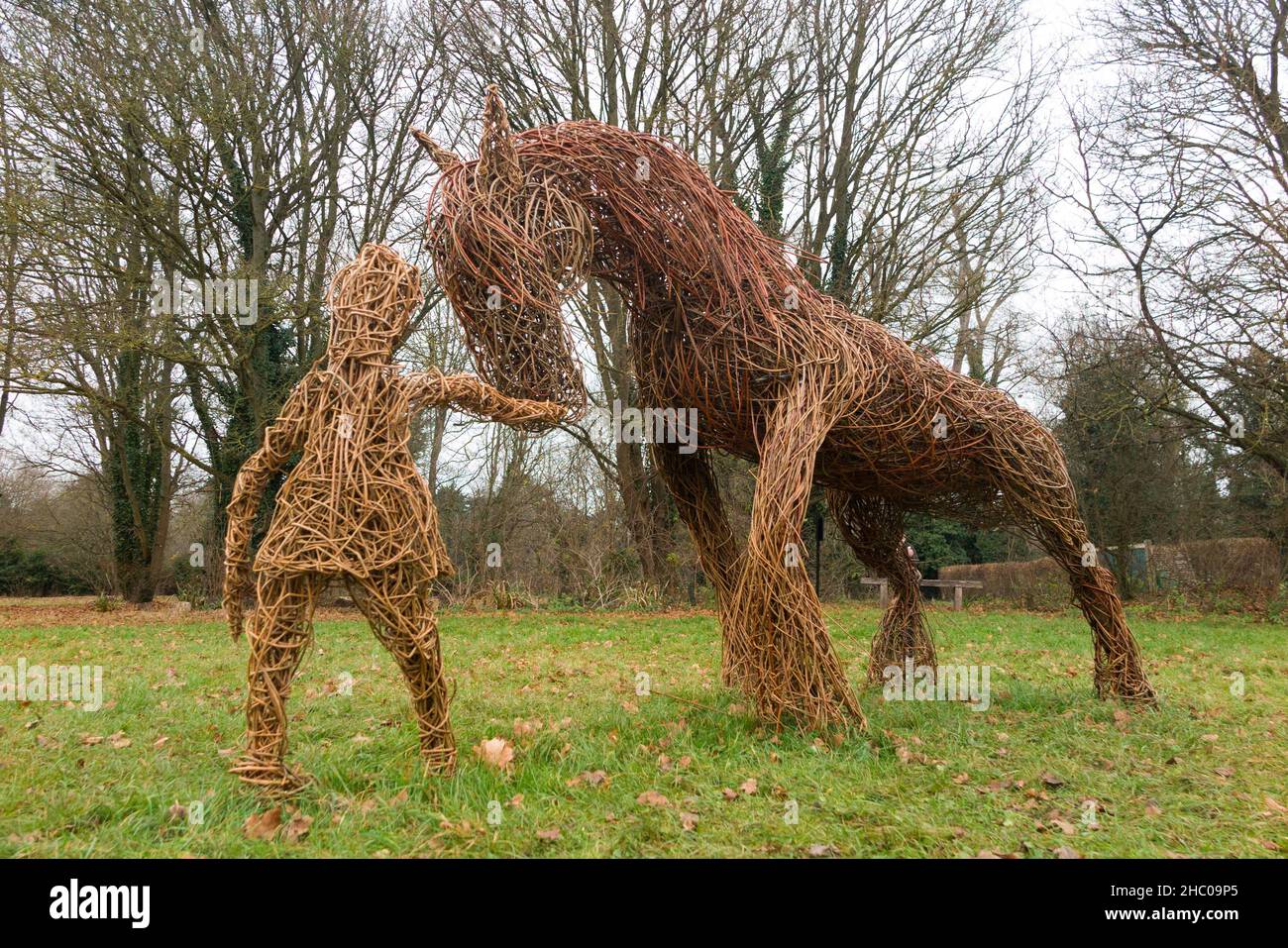 Scultura di persone antiche modellato da rami di Willow durante il periodo del raccolto e con il cavallo Shire e attrezzi scythe, in mostra a Runnymede, Surrey. REGNO UNITO. Runnymede fu il luogo della firma della Magna carta nel 1215. (127) Foto Stock