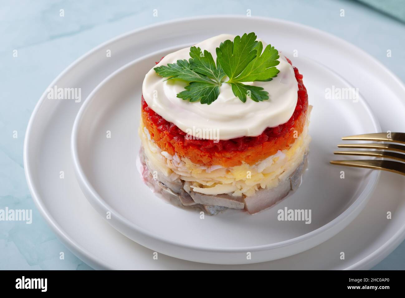 Insalata tradizionale russa con aringhe e verdure su sfondo verde Foto Stock