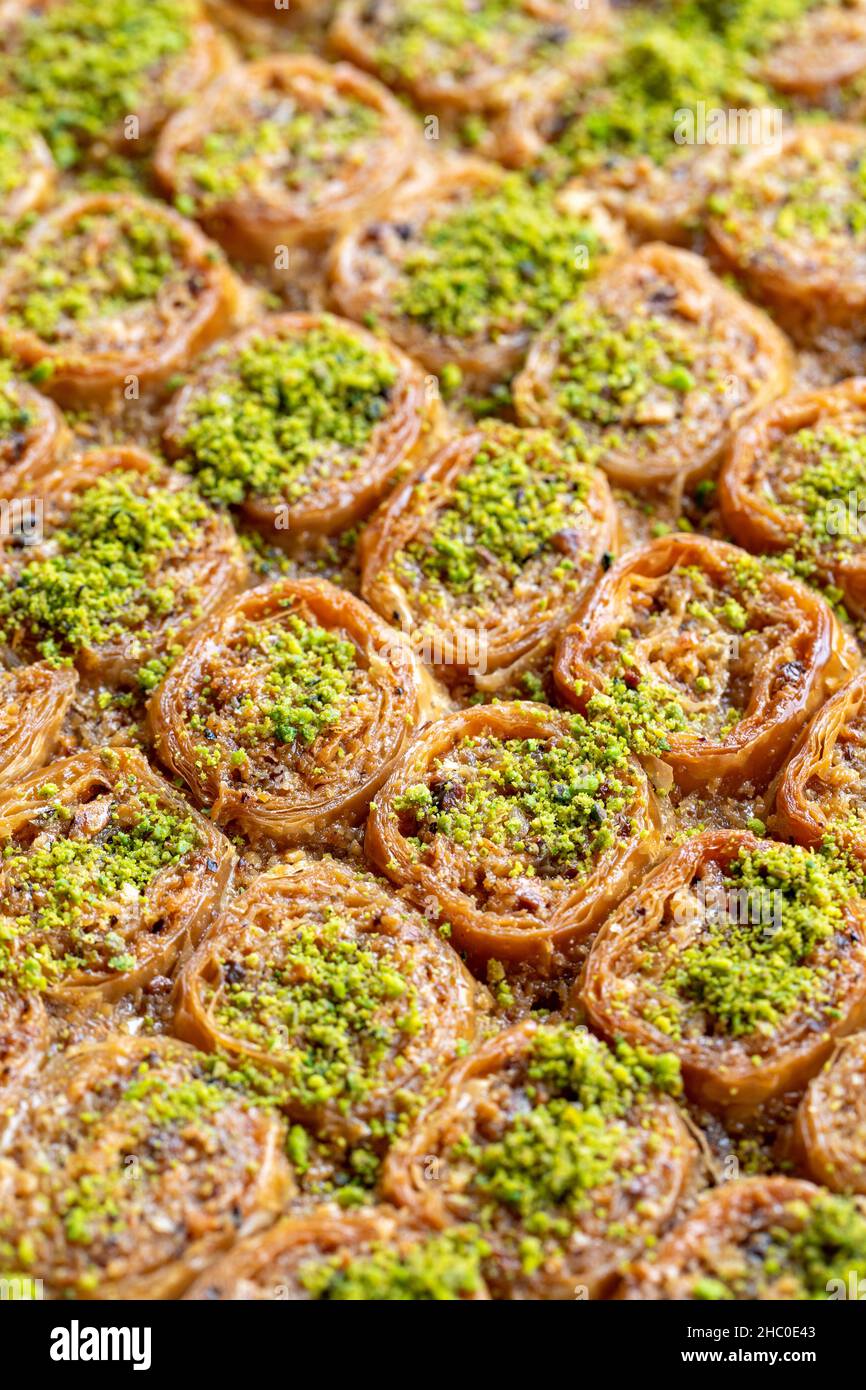 Dessert al pistacchio baklava su sfondo bianco. Dessert turco dolce concetto. Sherbet dolce panetteria mediterranea. Primo piano. Fuoco selettivo. Vertica Foto Stock