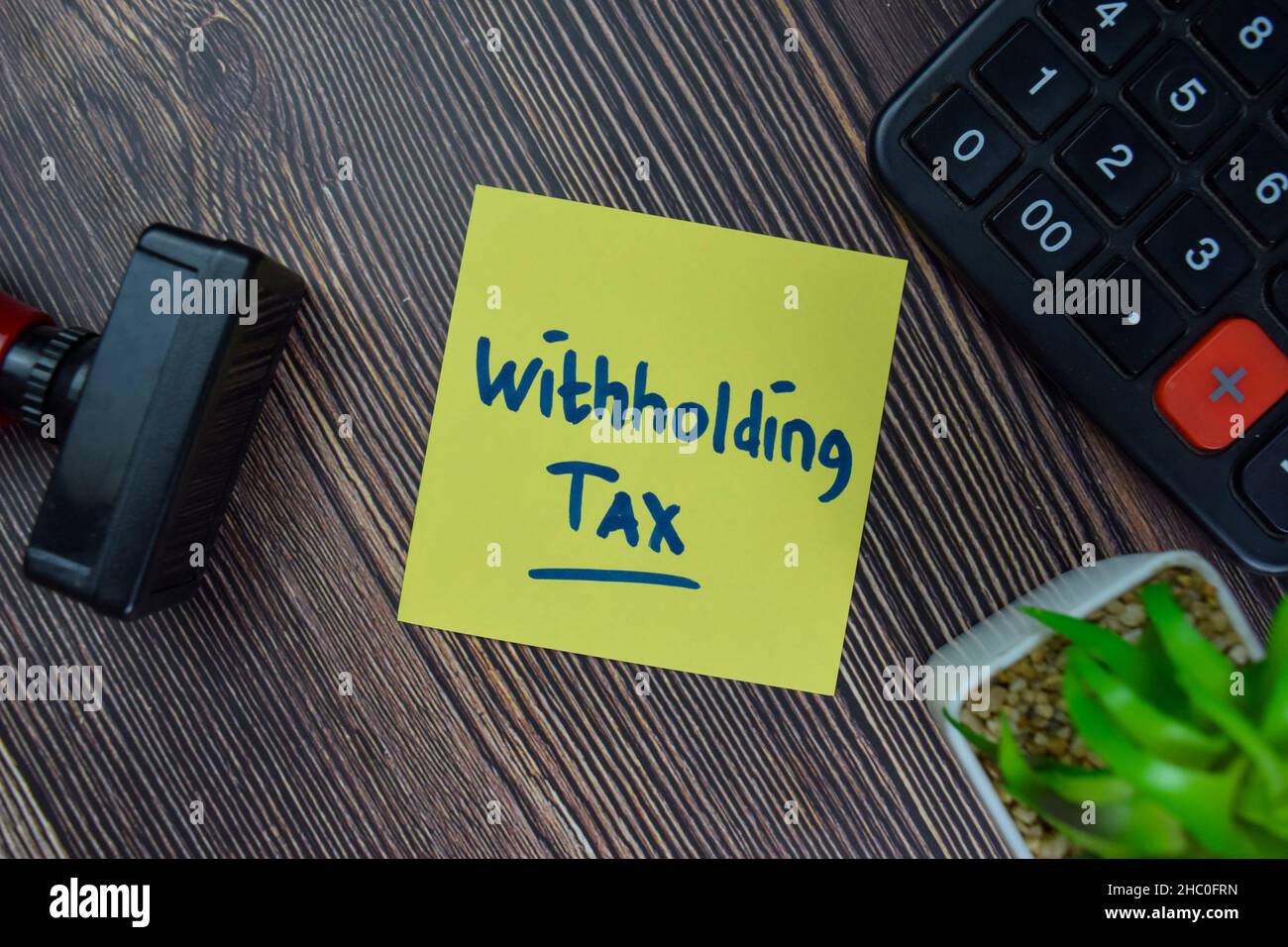 Ritenuta fiscale scrivere su note adesive isolate su tavola di legno. Foto Stock