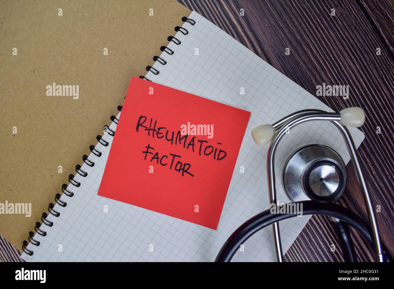 Fattore reumatoide scrivere su note appiccicose isolate su tavola di legno. Foto Stock