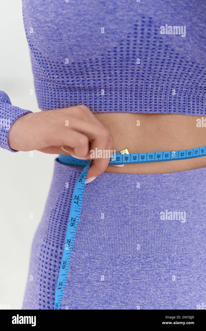 Donna in abbigliamento sportivo di tendenza con nastro di fissaggio. Ubicazione palestra Foto Stock