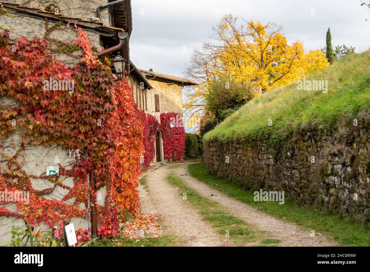 Le mura esterne del Castello Romena circondate dai colori caldi dell'autunno toscano, a stia Foto Stock