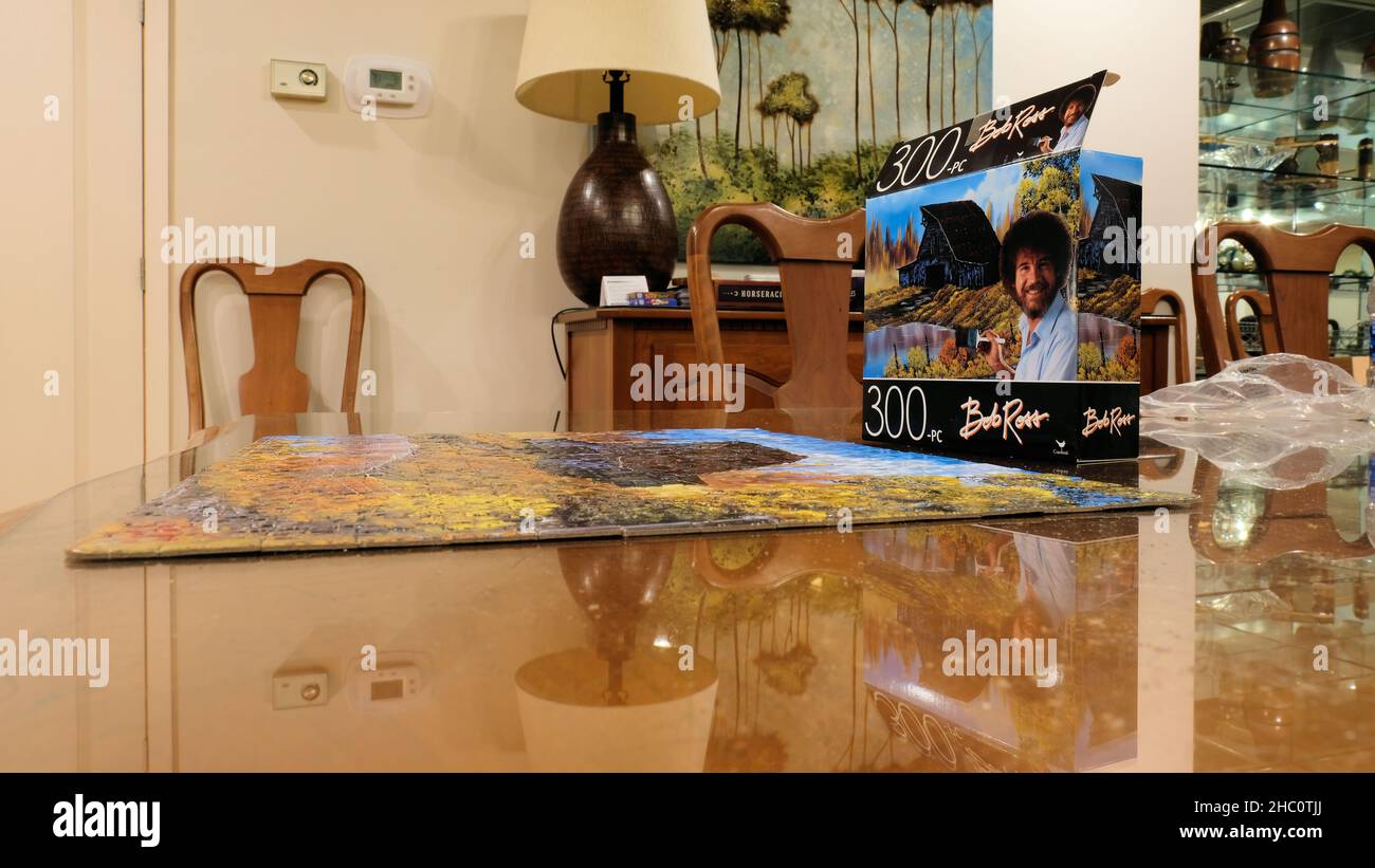 Completato Bob Ross 300-pezzo puzzle e scatola da Cardinal Games su un tavolo da pranzo in una casa interna. Foto Stock