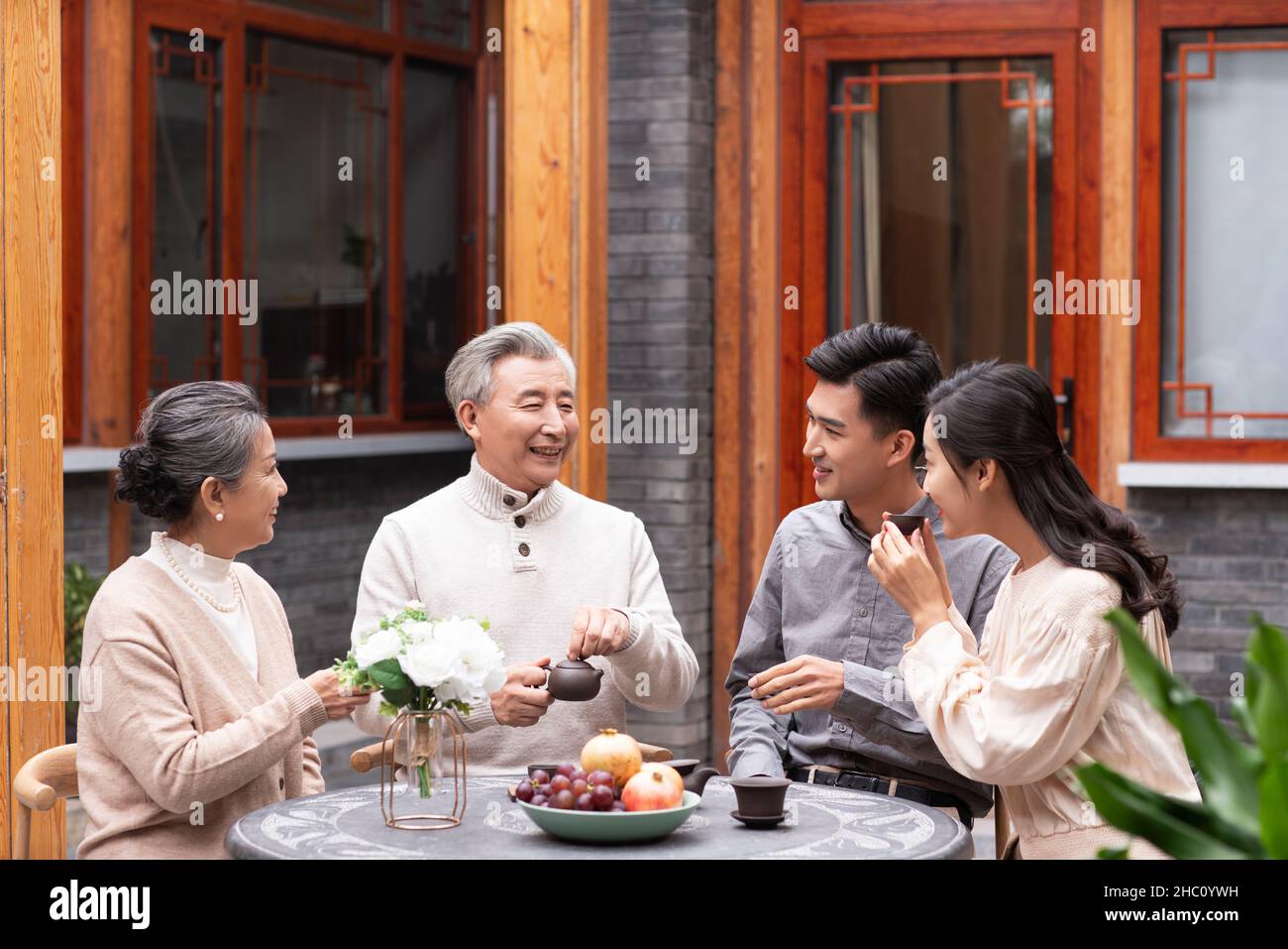 Famiglie felici che bevono il tè e chiacchierano nel cortile Foto Stock