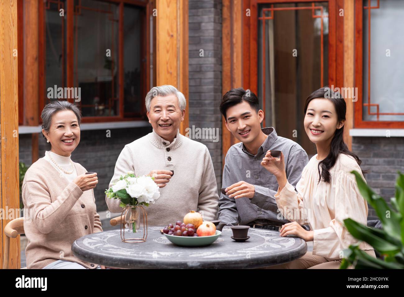 Famiglie felici che bevono il tè e chiacchierano nel cortile Foto Stock