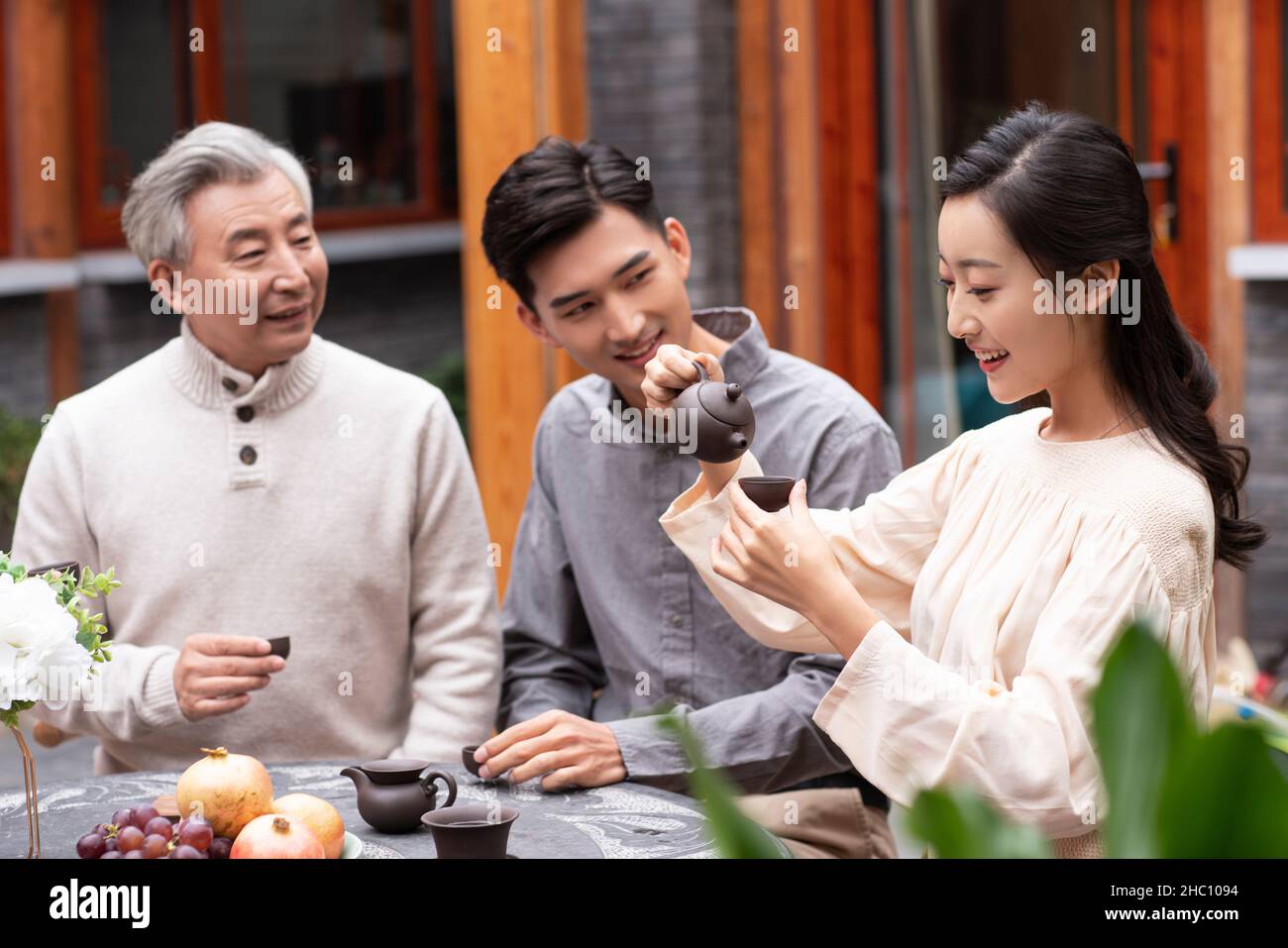 Famiglie felici che bevono il tè e chiacchierano nel cortile Foto Stock