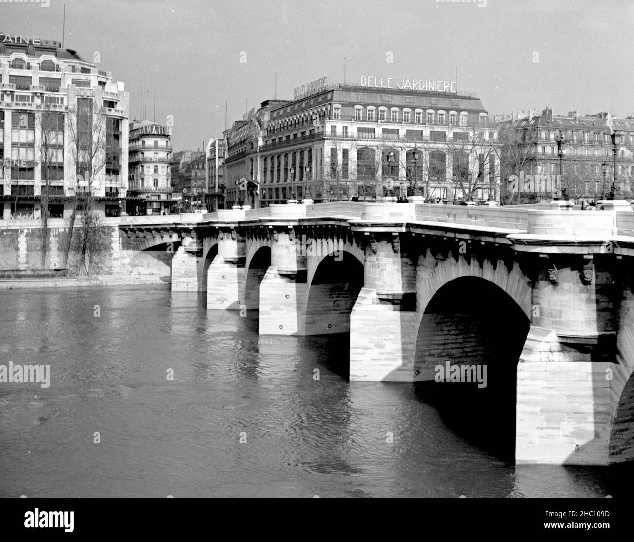 Parigi Pont Neuf, 1945. Fotografata dalla statua equestre di Henri IV, l'immagine cattura il ponte della Senna guardando dall'Ile de la Cite alla riva destra. Sono illustrati i bastioni circolari o baluardo sul ponte, così come i mascaroni gargoyle-like. Attraverso l'acqua, gli edifici sulla riva destra hanno segnaletica che indica Belle Jardiniere e Samaritaine. Foto Stock