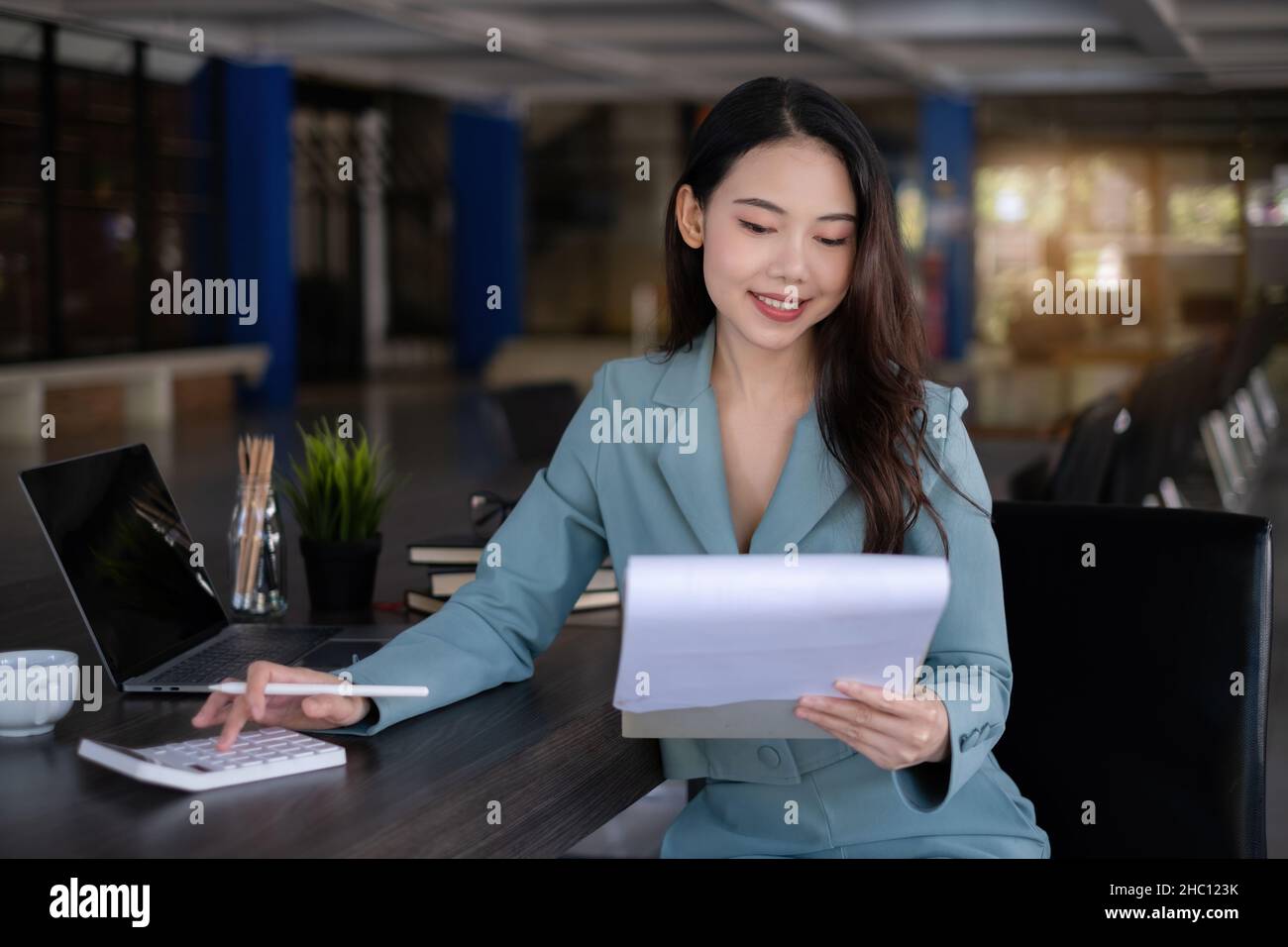 Donna d'affari con documento di dati e calcolo dei numeri di budget. Finanza, consulente, fatture, concetto fiscale. Foto Stock