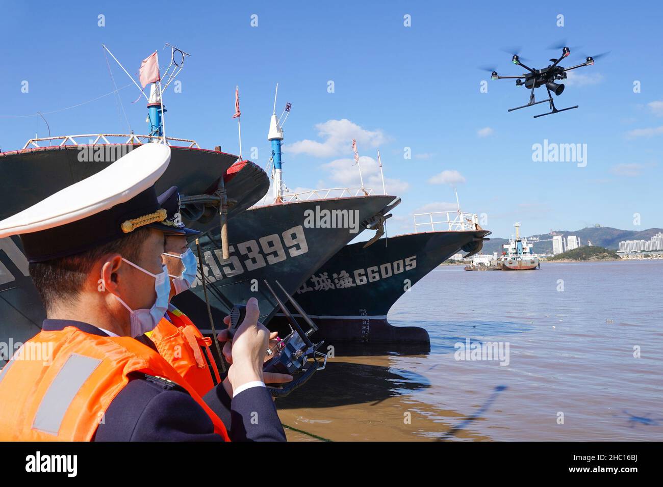 ZHOUSHAN, CINA - 23 DICEMBRE 2021 - gli agenti dell'applicazione della legge usano i droni della polizia per pattugliare l'area del porto e l'ancoraggio nella città di Zhoushan, la Prov di Zhejiang Foto Stock