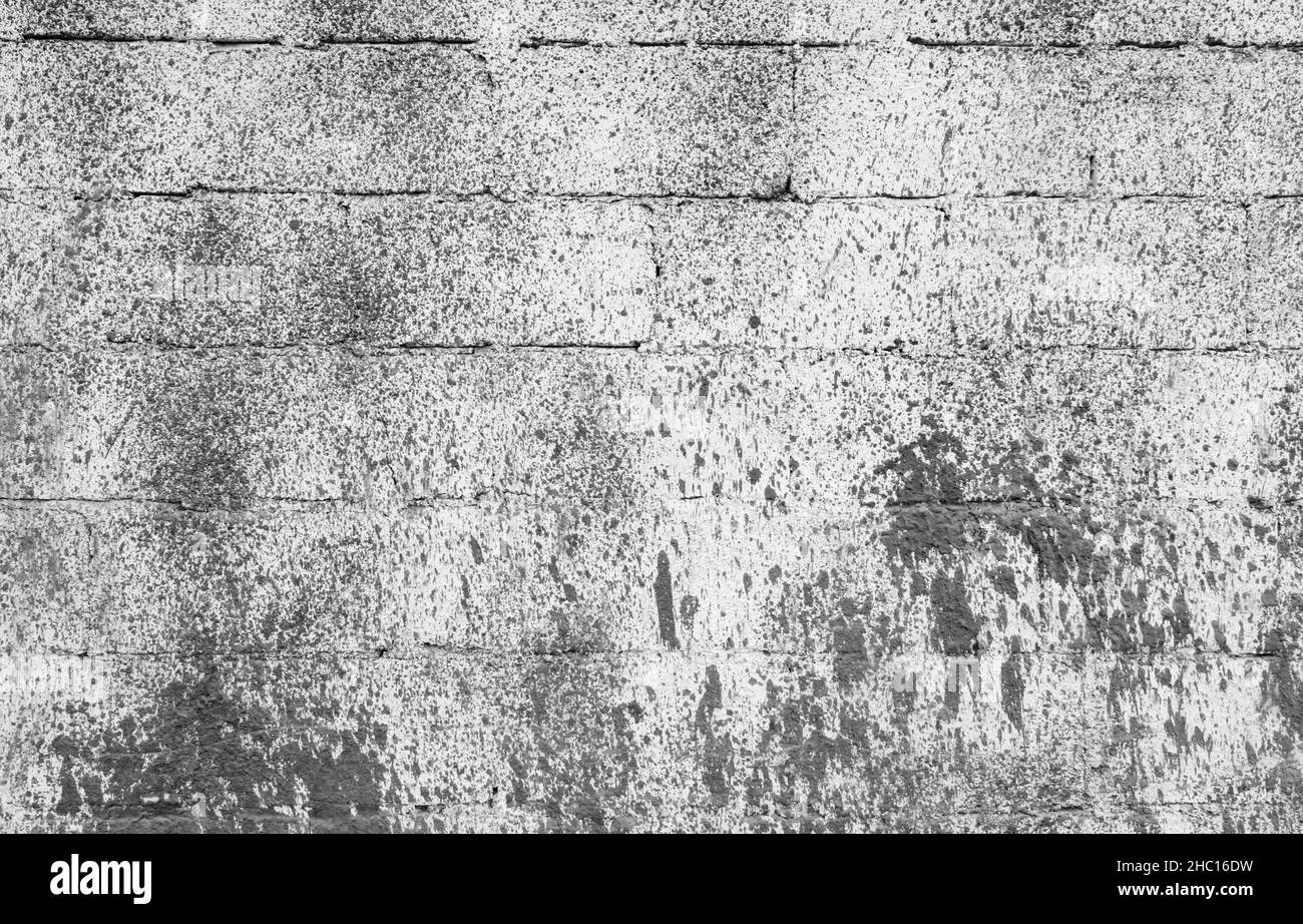 Vecchia parete di mattone grigio con spruzzi di vernice, trama di foto di sfondo Foto Stock