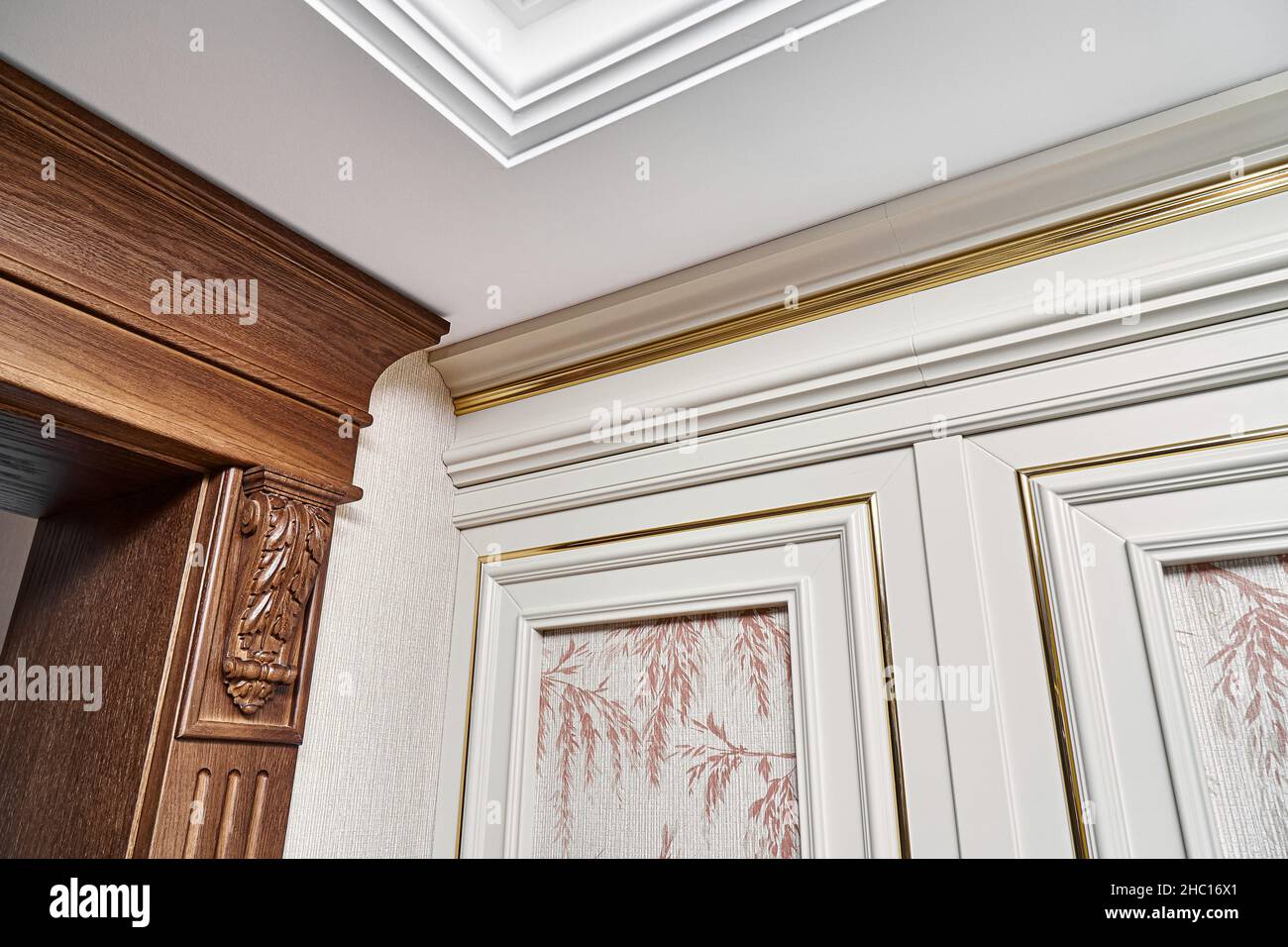 Porta decorata in legno con staffe per mobili intagliate e pannello scanalato e pannello vintage con stampaggio dorato in stile classico closeup Foto Stock Porta decorata in legno con staffe per mobili intagliate e pannello scanalato e pannello vintage con stampaggio dorato in stile classico closeup Foto Stock
