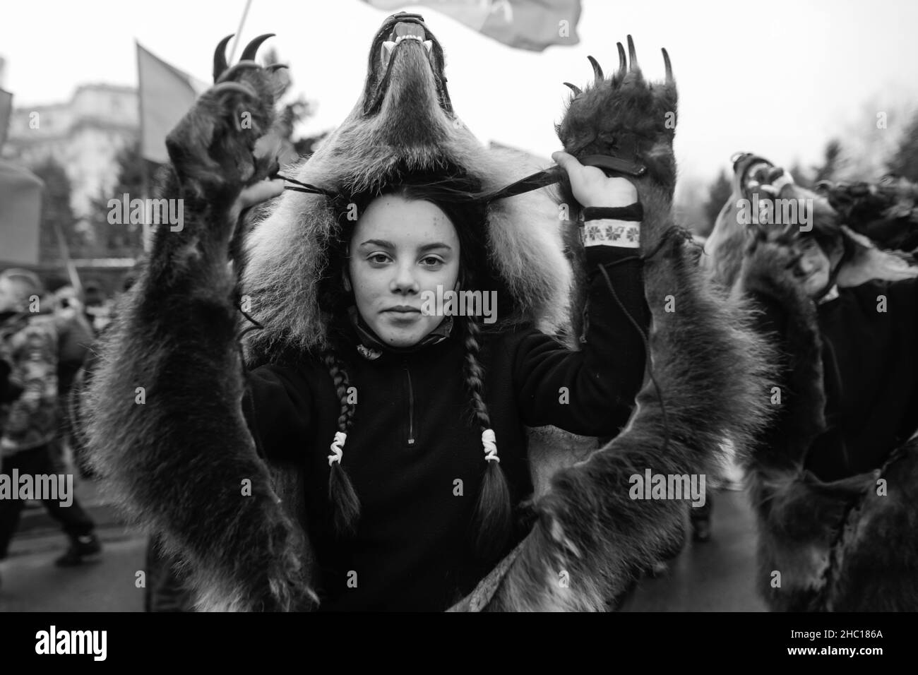 Bucarest, Romania - 21 dicembre 2021: La giovane donna indossa la pelliccia di orso e svolge un rituale tradizionale rumeno di Capodanno (Bears Dance o Dansul Urs Foto Stock