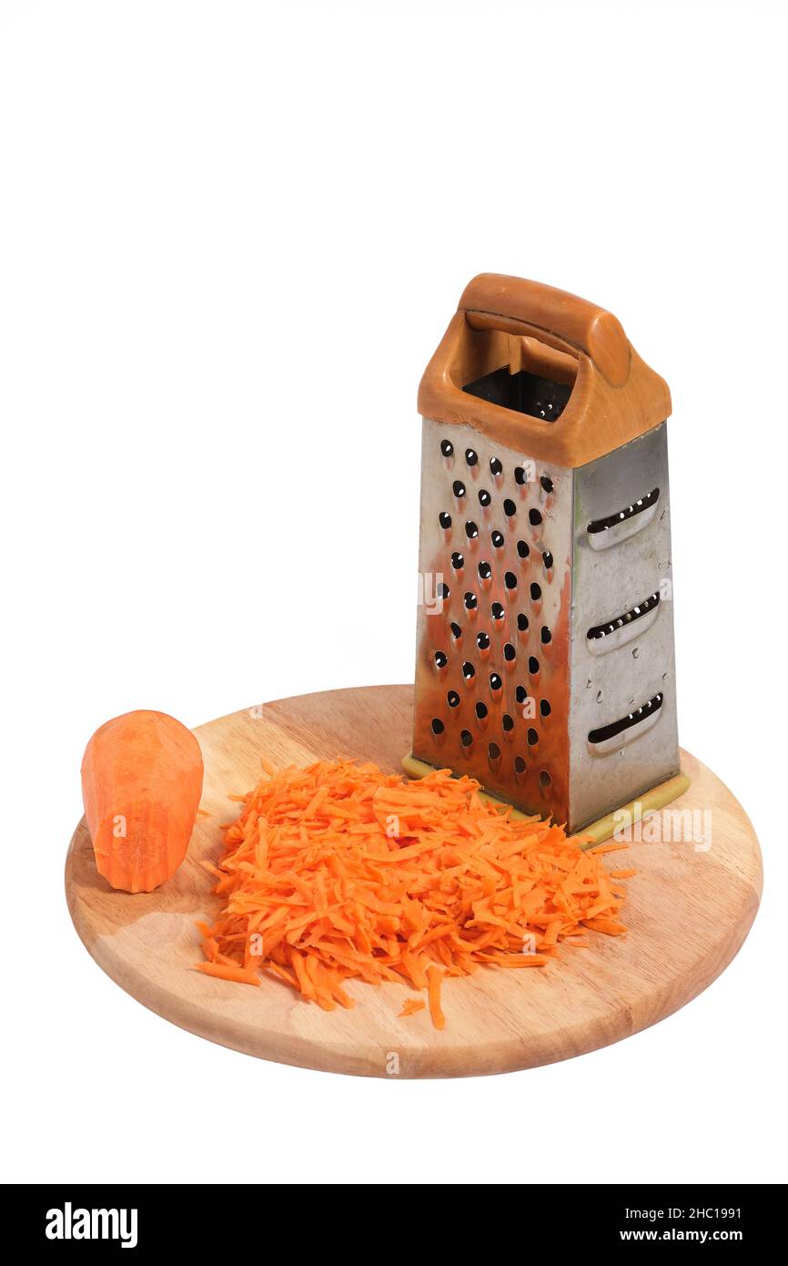 Grattugia per grattugiare e carote grattugiate su un tagliere Foto