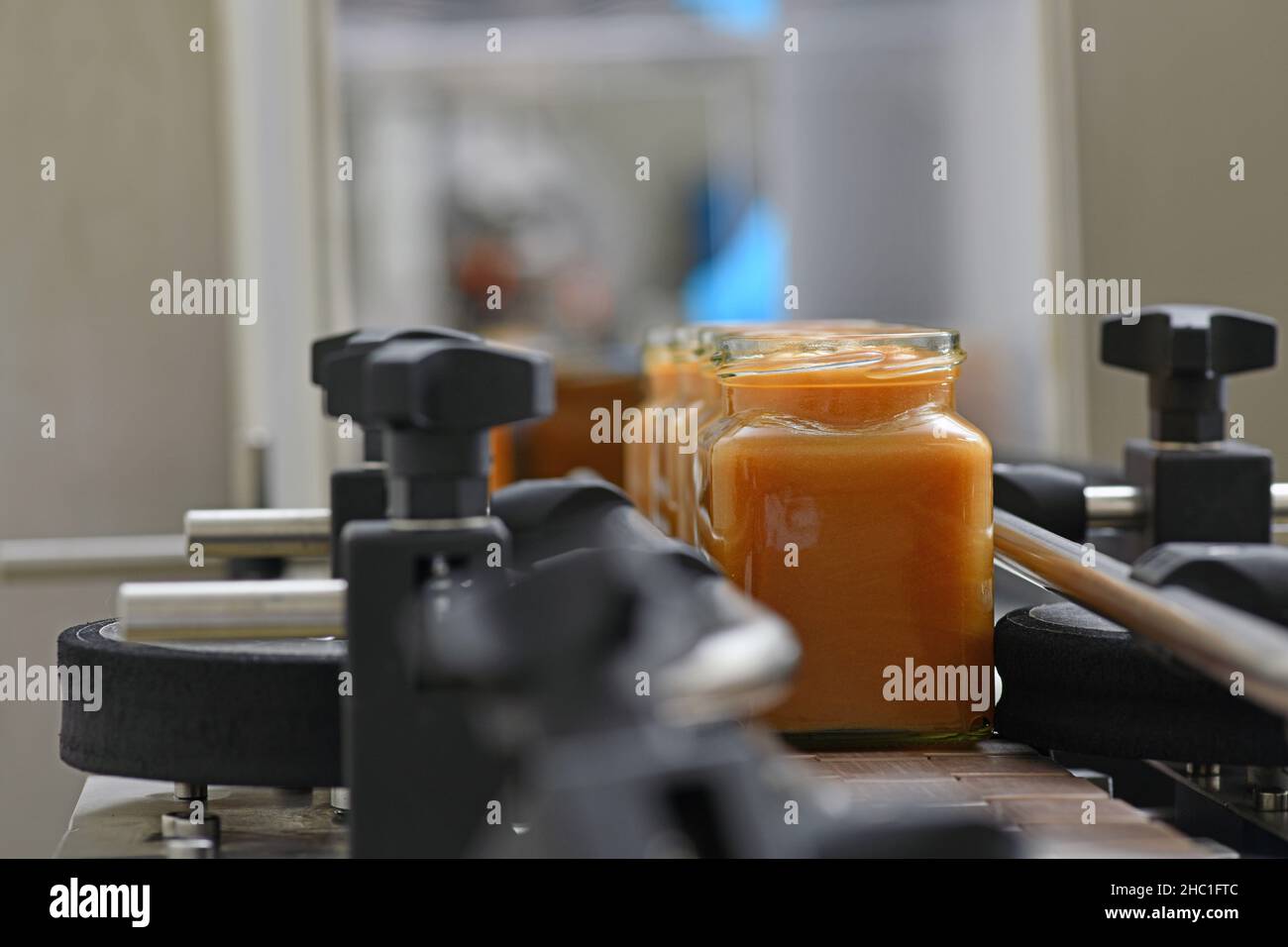Vasetti di miele cremato in una linea di confezionamento presso una fabbrica commerciale di miele Foto Stock