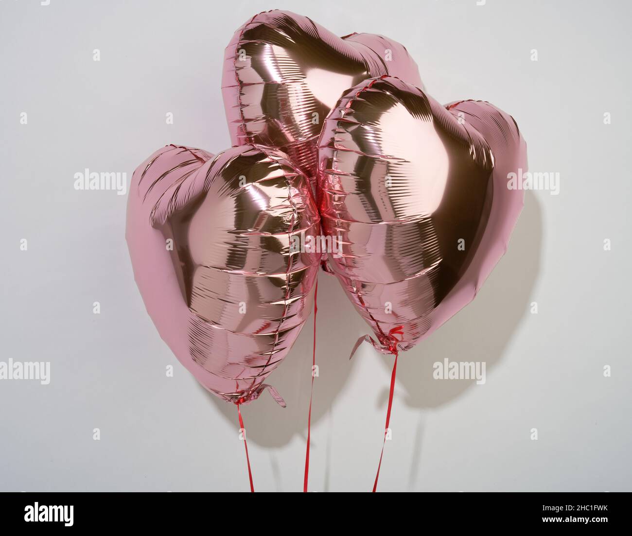 Un set di gettoni d'amore a forma di cuore. Un regalo per mostrare a uno l'amore per un altro. Palloncini rosa di elio. Foto Stock