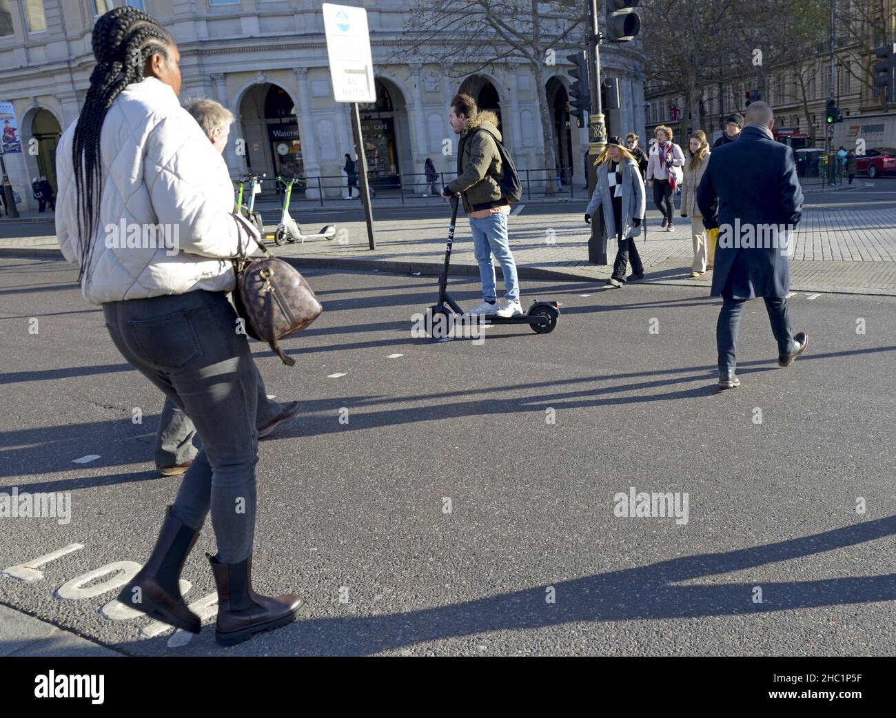 Londra, Inghilterra, Regno Unito. Uomo su uno scooter elettrico a Trafalgar Square Foto Stock