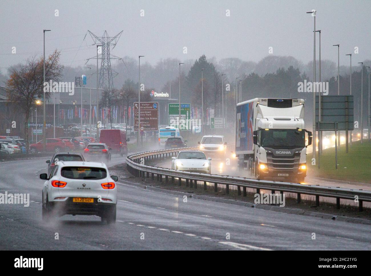 Dundee, Tayside, Scozia, Regno Unito. 23rd Dic 2021. UK Meteo: Il tempo nel Nord Est della Scozia è freddo e nebbia con forti docce persistenti e temperature che raggiungono i 4°C. Gli automobilisti della trafficata Dundee Kingsway West a doppia carreggiata si occupano di condizioni di guida pericolose e bagnate. Credit: Dundee Photographics/Alamy Live News Foto Stock