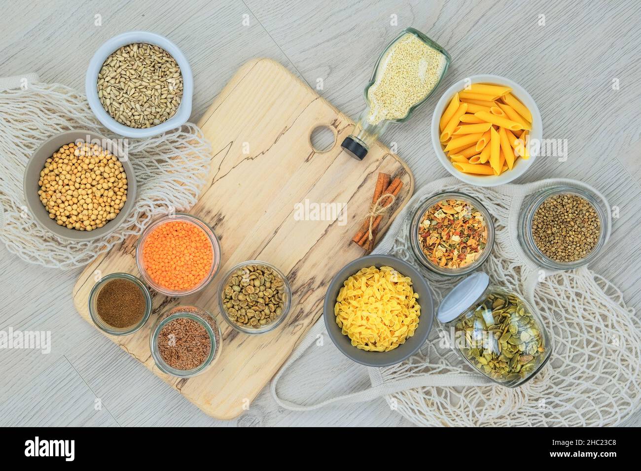 Semi di lino, semi di zucca, semi di sesamo, semi di girasole, semi di canapa, così come lenticchie, pasta, fagioli di soia e verdure essiccate in vasetti di vetro su un ligh Foto Stock